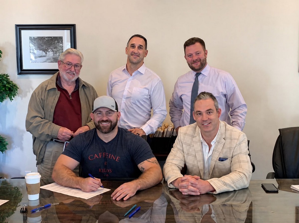 Landowner signing a development agreement at a conference table with four members of The Foundation Group team